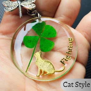 Handmade four leaf clover keychain with real clover preserved in clear resin, featuring a gold cat charm and personalized design