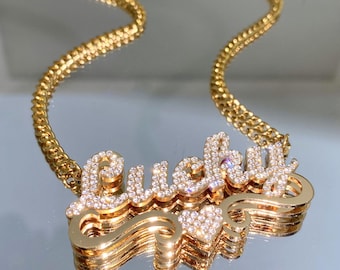 May include: Gold chain necklace with a large pendant that says "Lucky" in sparkly rhinestones. The pendant is layered and has a small heart charm.