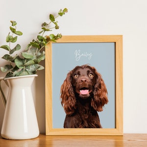 Depicts a cute cocker spaniel. The dog is sitting on a blue background and has its front paw raised. The dog has big, brown eyes and soft, shaggy fur.