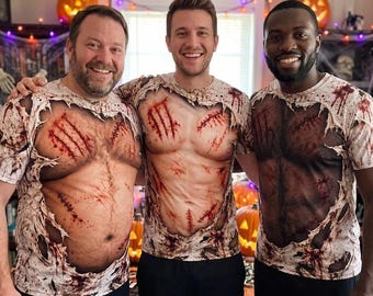 May include: Three short-sleeve t-shirts featuring a realistic graphic print of a torn, bloodied shirt revealing a muscular torso with claw marks and stitches. The print includes frayed fabric edges, red blood splatters, and dark chest hair details.