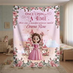 Könnte beinhalten: Eine rosa Decke zum Thema Prinzessin mit dem Text "Once Upon a Time" und "Emma Rose". Die Decke zeigt eine Cartoon-Prinzessin in einem rosa Kleid vor einem Schloss, umgeben von Rosen und Schmetterlingen.