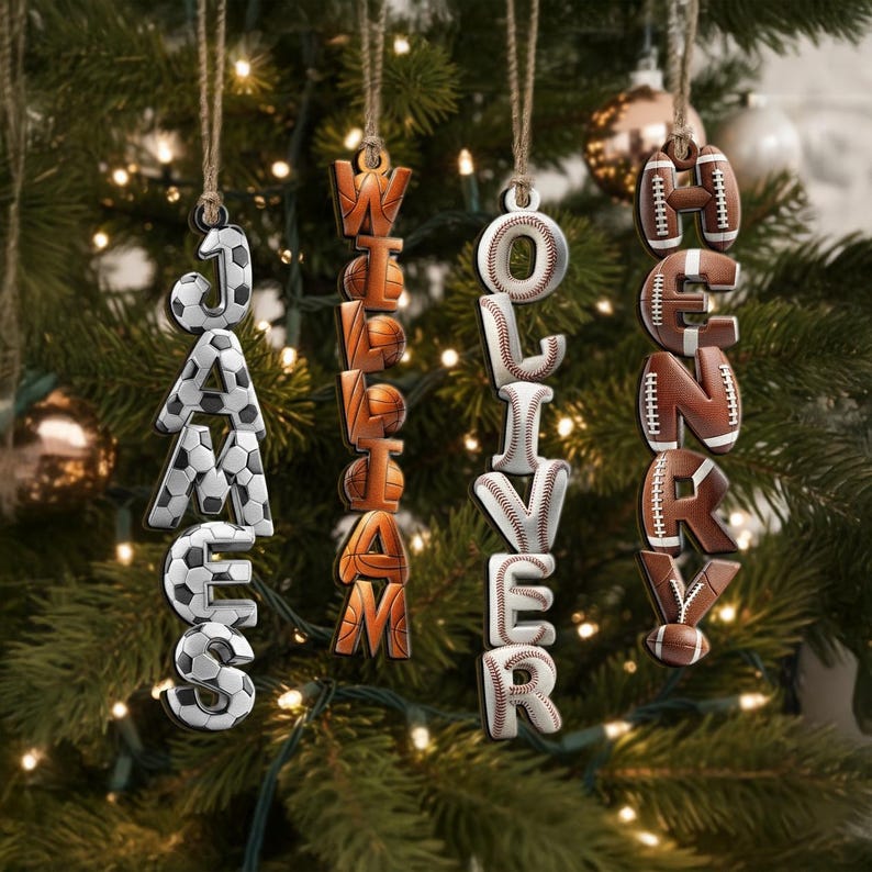 May include: Wooden Christmas ornaments spelling out names, each letter designed as a sports ball. Names include JAMES, WILLIAM, OLIVER, and HENRY. The ornaments hang from twine against a Christmas tree background.