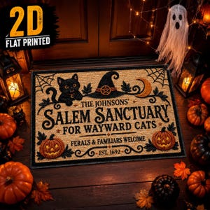 Peut inclure: Un paillasson rectangulaire beige avec le texte noir THE JOHNSONS' SALEM SANCTUARY FOR WAYWARD CATS, FERALS & FAMILIARS WELCOME, EST. 1692. Le motif comprend un chat noir, un chapeau de sorcière avec un pentagramme, des toiles d'araignée et des citrouilles.