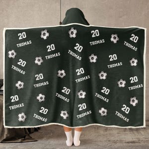 May include: Green hooded fleece blanket with a soccer ball pattern and the text "20 THOMAS" repeated throughout.