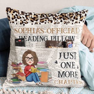 May include: A white pillow with a leopard print border and a book-themed design. The pillow has a pocket on the side and the text "Sophia's Official Reading Pillow Just One More Chapter" is printed on the front.