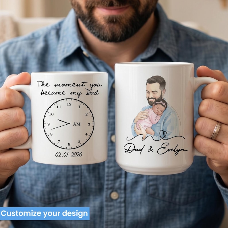 Pode incluir: Duas canecas de cer&acirc;mica branca. Uma caneca apresenta um design de rel&oacute;gio com o texto "The moment you became my Dad" e a data "02.01.2026". A outra caneca tem um desenho de um pai segurando um beb&ecirc;, com o texto "Dad & Evelyn".