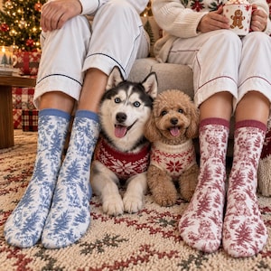 May include: Two pairs of crew socks featuring a toile-style pattern of dogs and pine trees. The left pair is blue and white, while the right pair is red and white. Both pairs are worn on legs, with a husky and a poodle sitting between them.