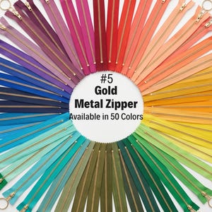 May include: A vibrant display of metal zippers in a rainbow of colors, arranged in a circular pattern. Each zipper has a gold pull and is available in a variety of shades, including red, orange, yellow, green, blue, and purple. The text reads "#5 Gold Metal Zipper Available in 50 Colors."