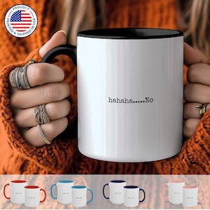 May include: White ceramic coffee mug with a black rim and handle. The mug has the text "hahaha....No" printed on the front.
