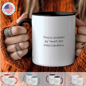 May include: White ceramic coffee mug with a black rim. The mug has black text that reads "People mistake my "wow"s for compliments..."