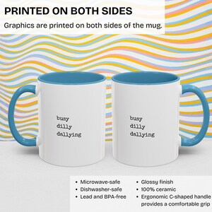 May include: White ceramic mug with a light blue rim and handle. The mug has the text "busy dilly dallying" printed on both sides. The mug is microwave, dishwasher, and lead and BPA free. It has a glossy finish and an ergonomic C-shaped handle.