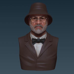 Pode incluir: Um busto de escultura de uma pessoa usando um chapéu marrom, um paletó marrom, uma camisa branca e uma gravata borboleta preta. A pessoa tem barba e bigode brancos e usa óculos.