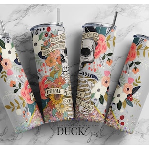 May include: Four stainless steel tumblers with a floral and skeleton design. The tumblers have a glitter finish and feature the text "Kinda Emo Kinda Emotional" and "Inhale Peace Exhale Chaos".