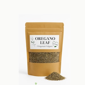 May include: A brown stand-up pouch containing dried oregano leaves with a clear window. The white label features the text OREGANO LEAF /Origanum Vulgare/ and a heart-shaped NATURAL logo. A small pile of dried green herbs sits in front of the pouch.