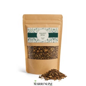 Può includere: Una busta in carta kraft marrone contenente pezzi di mallo di noce essiccati. L'etichetta presenta un motivo botanico verde e il testo Walnut Hull e Juglans Regia. Un piccolo mucchio di pezzi di mallo di noce marroni e ruvidi è posto davanti.