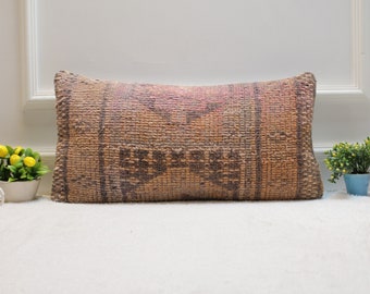 May include: A rectangular brown and beige patterned throw pillow with a woven texture.