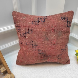 Op de afbeelding: Een rood en zwart gepatroneerd kussen met een geweven textuur. Het kussen is gemaakt van een zachte, comfortabele stof en is perfect om elke kamer een vleugje kleur en stijl te geven.