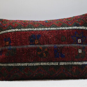 Peut inclure: Un coussin rectangulaire de couleur rouge, verte et bleue avec un motif tissé.