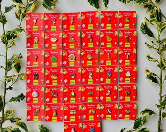 May include: A collection of thirty-five individual enamel pins displayed on red square backing cards labelled Christmas Mini Pin and kanjam. Each pin features a unique holiday-themed design, including ornaments, food, and festive symbols.
