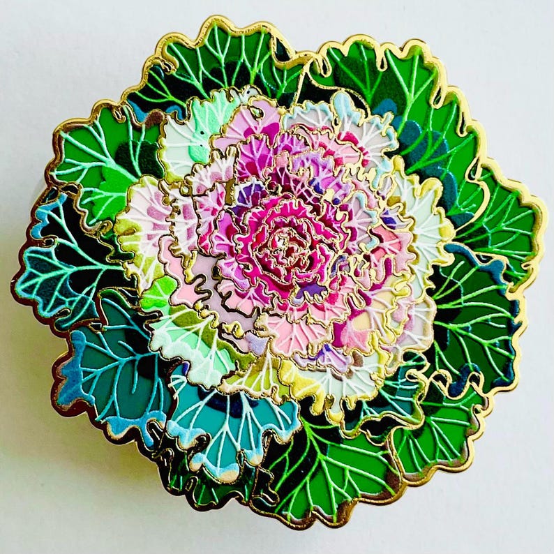 a vibrant, intricately designed flower with a variety of colors, including pink, green, and white. The flower is surrounded by a lush, green leafy background, creating a visually striking and detailed composition.