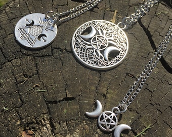 May include: Three silver-toned pendant necklaces with intricate designs. One features a circle with a geometric pattern, another a Celtic knot design with a pentagram and crescent moons, and the third a pentagram between two crescent moons.