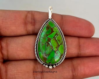 May include: A teardrop-shaped pendant with a green turquoise stone set in a silver bezel with a rope-like border. The pendant has a silver bail at the top.