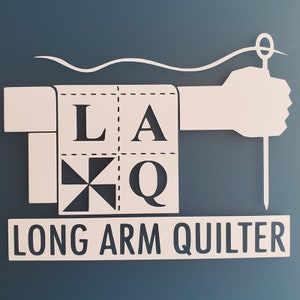 May include: A white logo on a blue background with the text "LAQ LONG ARM QUILTER". The logo features a stylized quilt block with the letters "LAQ" and a hand holding a needle and thread.