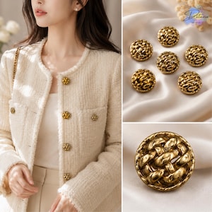 May include: A cream-colored tweed jacket featuring a round neckline and frayed edges, adorned with multiple round gold-toned buttons. The buttons have a textured, woven metal design. A close-up view shows the intricate braided gold metal pattern.