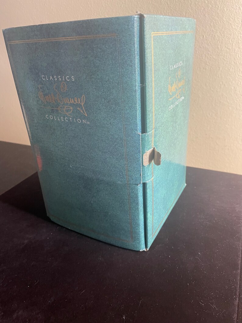 May include: A teal blue box with gold trim and the text "Classics of Walt Disney Collection" on the front.
