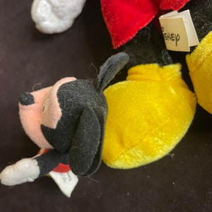 K&ouml;nnte beinhalten: Nahaufnahme eines Pl&uuml;schtier-Sets mit Mickey Mouse und Pluto. Mickey tr&auml;gt seine charakteristischen roten Shorts und gelben Schuhe. Pluto tr&auml;gt ein rotes Halsband. Die Spielzeuge haben ein Disney-Etikett.