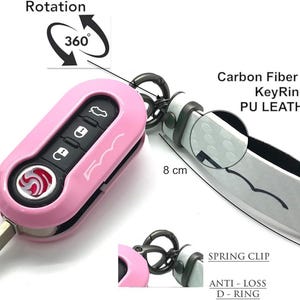 May include: A pink car key fob with a carbon fibre design keyring. The key fob is 8 cm long and 2 cm wide. The keyring has a spring clip and an anti-loss D-ring.