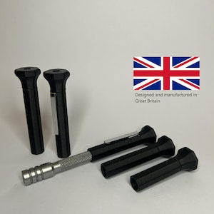 May include: A set of black precision tools with silver accents. The tools include several black handles and a silver, textured handle. The image also includes the text "Designed and manufactured in Great Britain" next to the British flag.