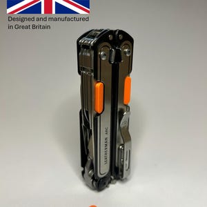 May include: A multi-tool with a black and silver finish, accented with bright orange grips. The tool is labeled "LEATHERMAN ARC" and includes a pocket clip. An orange accessory is placed near the tool. The image includes the text "Designed and manufactured in Great Britain."