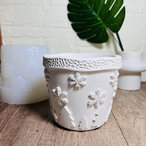Pode incluir: Vaso de cerâmica branco com borda texturizada e desenhos de flocos de neve e pinheiros.