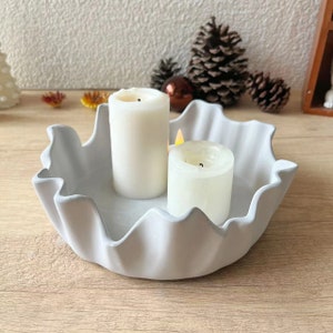 Pode incluir: Castiçal de cerâmica branca com borda ondulada, com duas velas brancas.