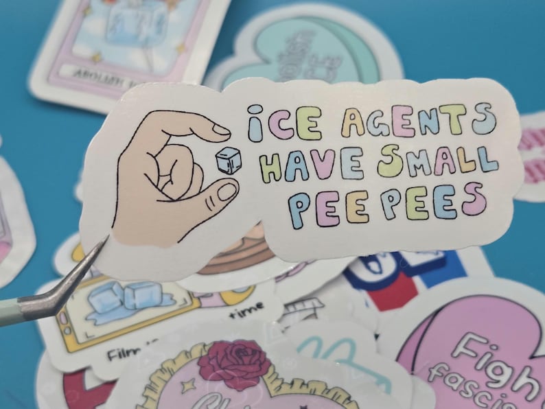 以下が含まれることがあります： パステルカラーで「ICE AGENTS HAVE SMALL PEE PEE'S」と書かれた白いステッカー。小さな氷のキューブを持っている手が表示されています。他のステッカーが背景に見えます。