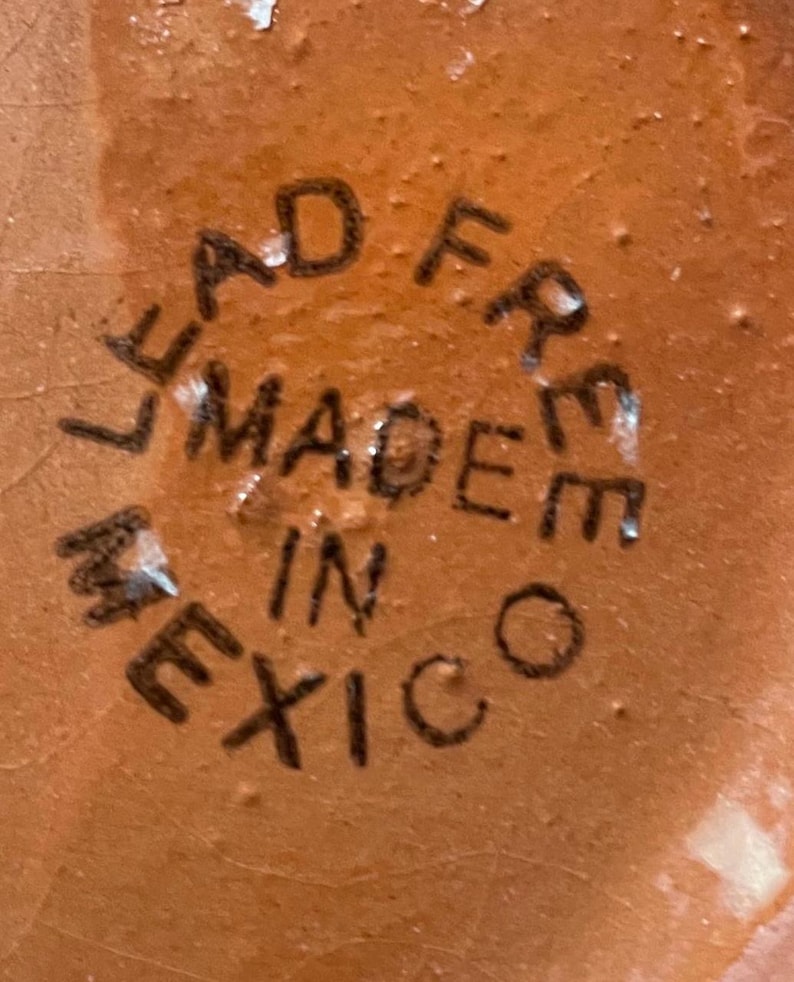 May include: Close-up of a brown ceramic object with the text "Lead Free Made in Mexico" stamped on the bottom.