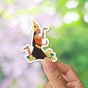 May include: A sticker featuring a woman in a traditional Cambodian dance costume, with a golden crown and a red and gold dress. She is kneeling with her arms raised, and there are yellow flowers around her.