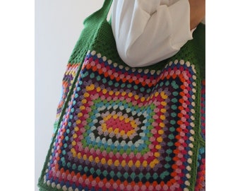 May include: A large green crochet tote bag with a colorful granny square design. The bag has a single strap and is made with a variety of bright colors.