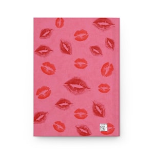 May include: Pink notebook cover with a repeating pattern of red lipstick kiss marks.