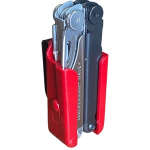 Könnte beinhalten: Ein rotes und schwarzes Multitool-Etui mit einem Leatherman Wave+ Multitool im Inneren. Das Etui hat einen Gürtelclip.