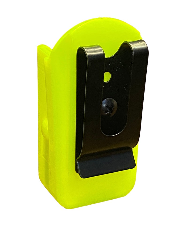 Puede incluir: Un clip de cintur&oacute;n de pl&aacute;stico amarillo brillante con un clip de metal negro. El clip est&aacute; dise&ntilde;ado para sujetar una linterna u otra herramienta peque&ntilde;a.