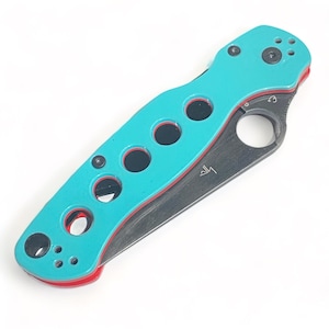 May include: A turquoise and red pocket knife with a black blade and a hole in the handle. The handle has a series of holes in a pattern.