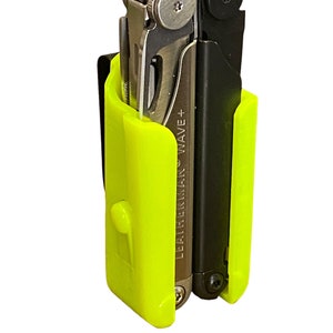 Puede incluir: Una funda amarilla brillante para multiherramientas con una multiherramienta Leatherman Wave+ negra en su interior.