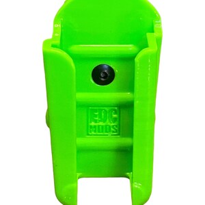 Puede incluir: Un soporte de pared de pl&aacute;stico verde brillante con un agujero para tornillo y el texto "EDC Mods" en relieve en la parte delantera.