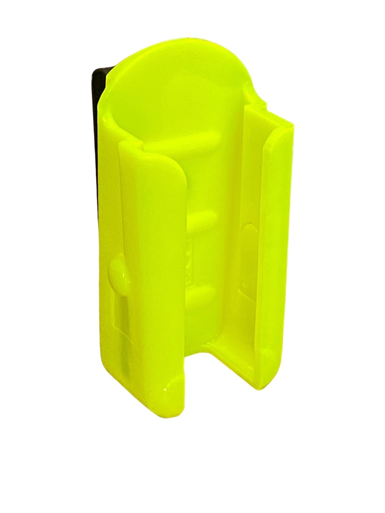 Puede incluir: Un clip de pl&aacute;stico amarillo brillante dise&ntilde;ado para sujetar una linterna u otro objeto peque&ntilde;o. El clip tiene una correa de pl&aacute;stico negro para sujetarlo a un cintur&oacute;n u otra superficie.