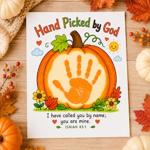 May include: A white rectangular print featuring the text Hand Picked by God at the top and I have called you by name; you are mine. ISAIAH 43:1 at the bottom. A large orange pumpkin illustration with a central orange handprint, flowers, and sun.