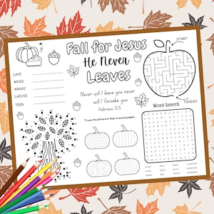 May include: A white activity sheet with fall-themed illustrations and text. The sheet includes a maze, word search, connect-the-dots, and pumpkin designs. Text reads "Fall for Jesus He Never Leaves" and a Bible verse. Colored pencils are in the lower left corner.
