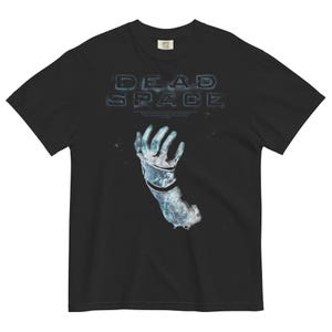 Puede incluir: Camiseta negra con un gráfico blanco de una mano que sale de una superficie congelada y agrietada. El texto "DEAD SPACE" está impreso sobre la mano.