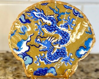 Decoupage Chinese dragon on a hand painted flat scallop shell. The dragon symbolizes good luck, strength, and health. Gold stand additional.